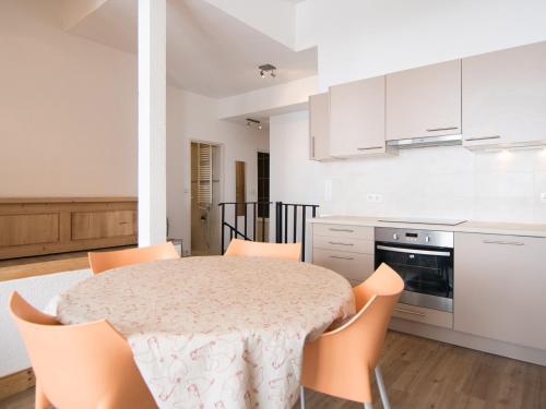 une cuisine blanche avec une table et des chaises dans l'établissement Duplex 3 pièces au pied des pistes avec WiFi à Tignes - FR-1-449-70, à Tignes