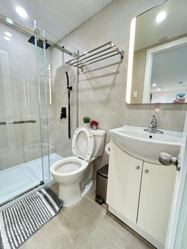 a bathroom with a toilet and a sink and a shower at Modern Lux Family Rooms - KingBed - Near Sheppard W Station Toronto in Toronto