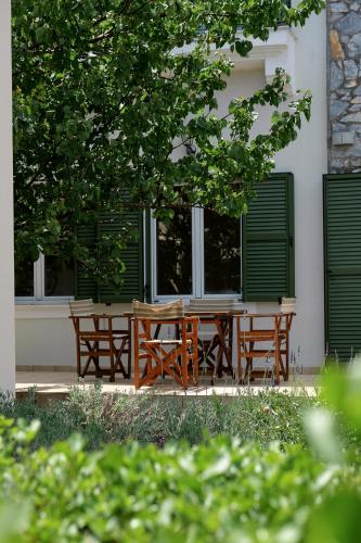 a wooden table and benches in front of a building at Art Lesvos Villa in Pyrgi Thermis