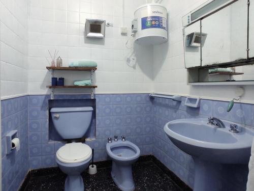 a blue and white bathroom with a toilet and a sink at Alquiler de casa temporario en Suipacha "Lo de Juancho" in Suipacha
