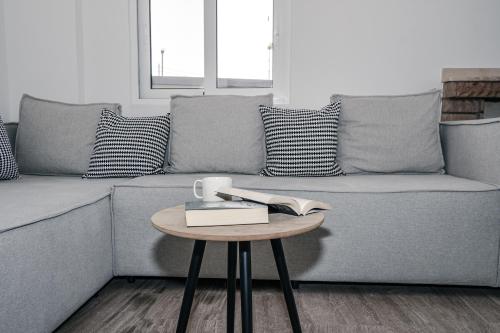 a living room with a couch with a table with a book at Panorama Sea View Residence in Gargaliánoi