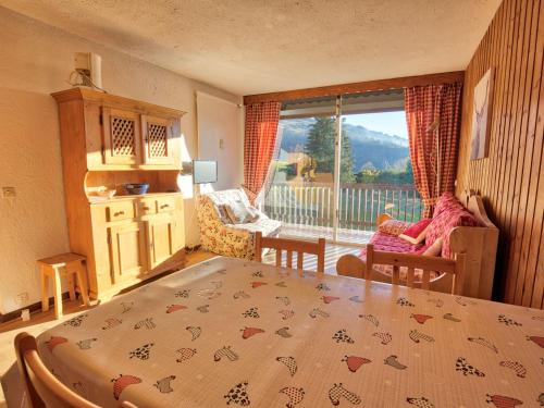 - une chambre avec une table, des chaises et une fenêtre dans l'établissement Appartement cosy à Notre-Dame-de-Bellecombe, piscine, skis aux pieds - FR-1-505-74, à Notre-Dame-de-Bellecombe