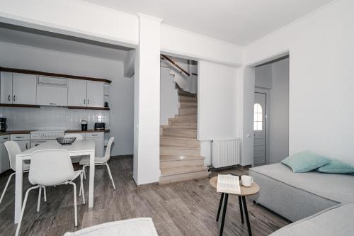 a living room with a couch and a table and a kitchen at Panorama Sea View Residence in Gargaliánoi