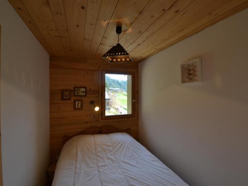 une chambre avec un lit dans une pièce avec une fenêtre dans l'établissement Appartement chaleureux avec balcon et parking privatif - FR-1-505-116, à Notre-Dame-de-Bellecombe