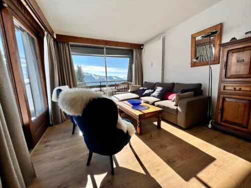 un salon avec un canapé et une table dans l'établissement Appartement proche des pistes avec piscine, tennis et WiFi - FR-1-505-127, à Notre-Dame-de-Bellecombe