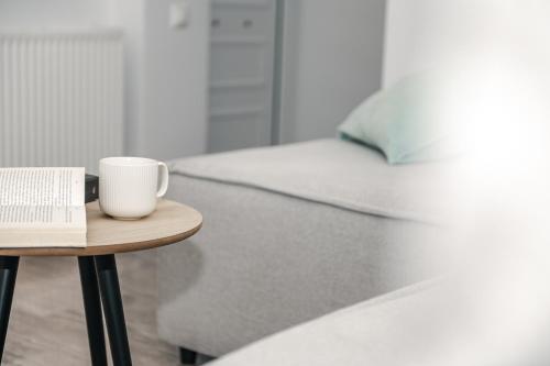 a coffee cup on a table next to a bed at Panorama Sea View Residence in Gargaliánoi