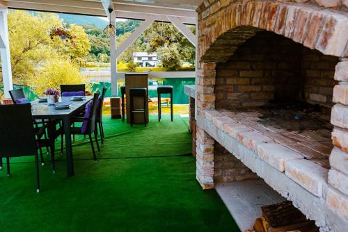 a patio with a brick fireplace and a table and chairs at Una deluxe home ELLA in Bihać
