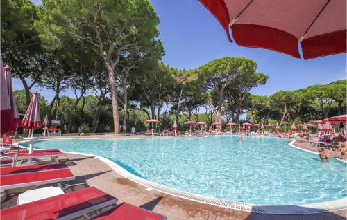 a large swimming pool with chairs and umbrellas at Cozy Apartment In Puntone With Wifi in Puntone di Scarlino