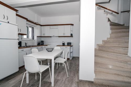 a kitchen with a table and chairs and a staircase at Panorama Sea View Residence in Gargaliánoi