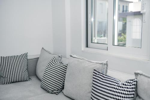 a bunch of pillows sitting on a couch with two windows at Panorama Sea View Residence in Gargaliánoi