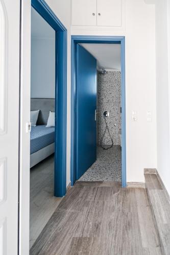a blue door leading to a bedroom with a bed at Panorama Sea View Residence in Gargaliánoi
