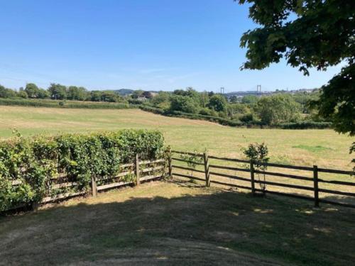 una valla de madera en un campo con césped en Cockles Farm Bungalow, en Saltash