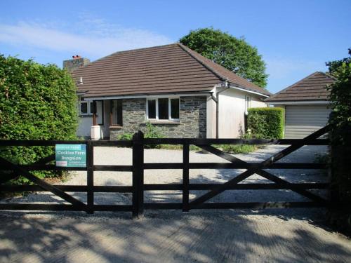 una valla de madera delante de una casa en Cockles Farm Bungalow, en Saltash