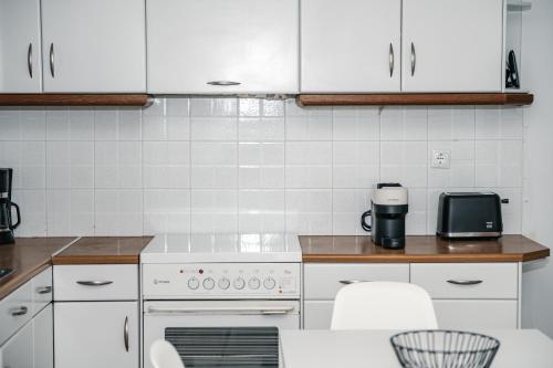 a kitchen with white appliances and white cabinets at Panorama Sea View Residence in Gargaliánoi