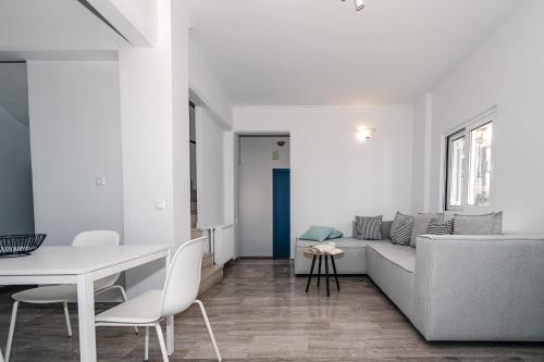 a white living room with a couch and a table at Panorama Sea View Residence in Gargaliánoi