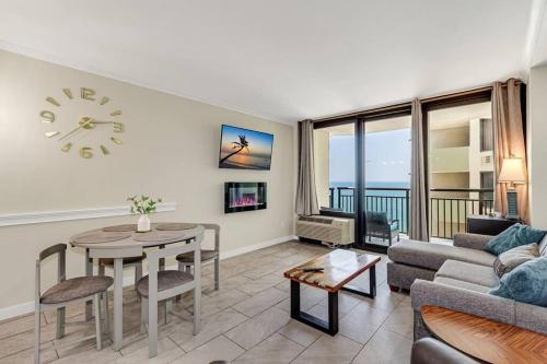 a living room with a table and a clock on the wall at Remodeled Oceanview Suite, Small Dogs OK 1738 in Myrtle Beach