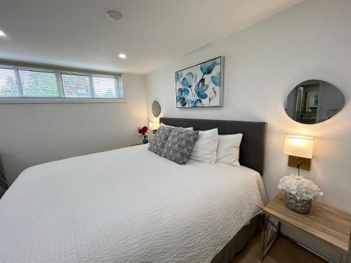 a bedroom with a white bed and a mirror at Modern Lux Family Rooms - KingBed - Near Sheppard W Station Toronto in Toronto