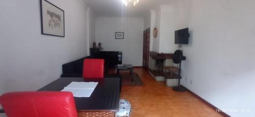 a living room with a table and red chairs at APART Alojamentos Para Turismo e Negocios in Braga