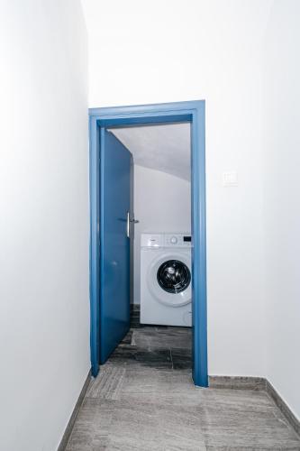 an open blue door with a washing machine in a room at Panorama Sea View Residence in Gargaliánoi