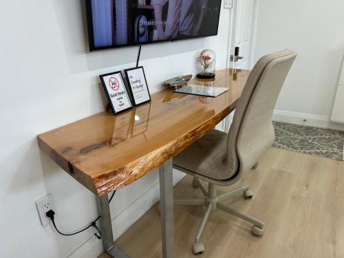 a wooden desk with a chair next to a wall at Modern Lux Family Rooms - KingBed - Near Sheppard W Station Toronto in Toronto