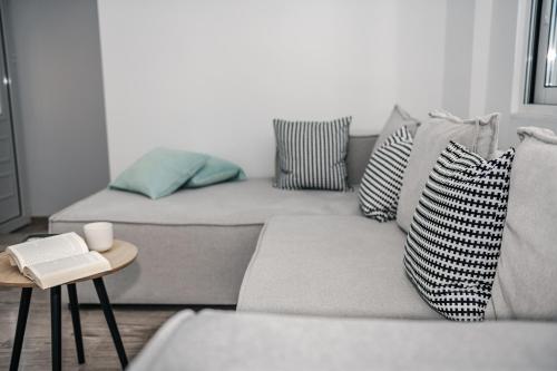 a living room with a couch with pillows and a table at Panorama Sea View Residence in Gargaliánoi