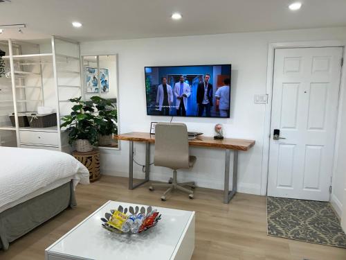 a bedroom with a bed and a desk with a tv on the wall at Modern Lux Family Rooms - KingBed - Near Sheppard W Station Toronto in Toronto