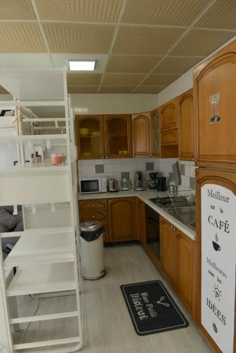 une cuisine avec des armoires en bois et un comptoir blanc dans l'établissement studio, à Berck-sur-Mer