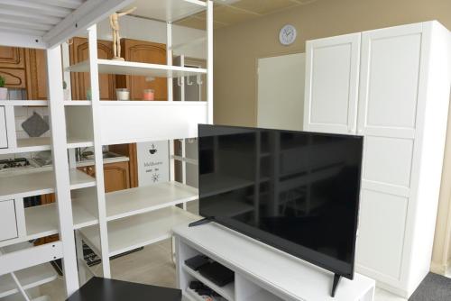 un salon avec une grande télévision à écran plat dans l'établissement studio, à Berck-sur-Mer