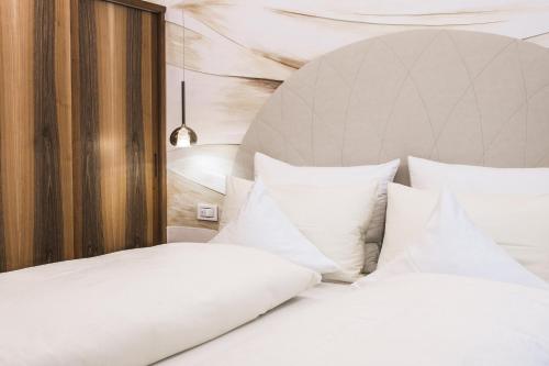 a bedroom with two beds with white pillows at Apartments Villa Venezia Luxury in Ortisei