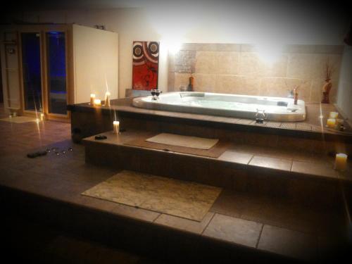 a bathroom with a tub with two candles and a candle at Casale Valle Agnese in Godrano
