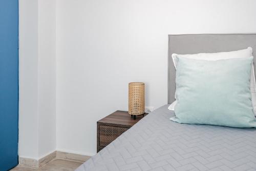 a bed with a blue pillow and a night stand at Panorama Sea View Residence in Gargaliánoi