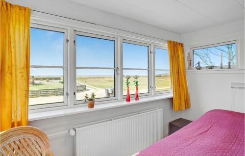 a bedroom with windows and a bed with pink sheets at Holiday Home Helnæsvej Haarby Ix in Brunshuse
