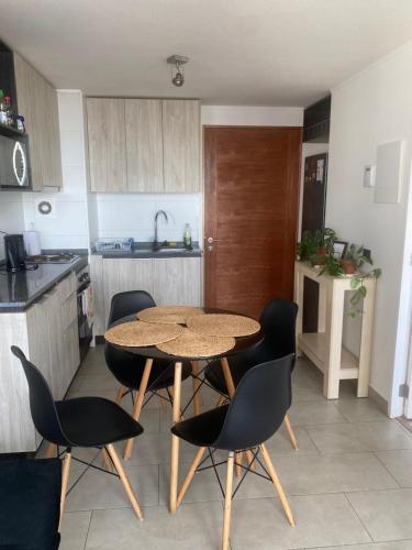 a kitchen with a table and chairs in a kitchen at Departamento Central Valdivia in Valdivia
