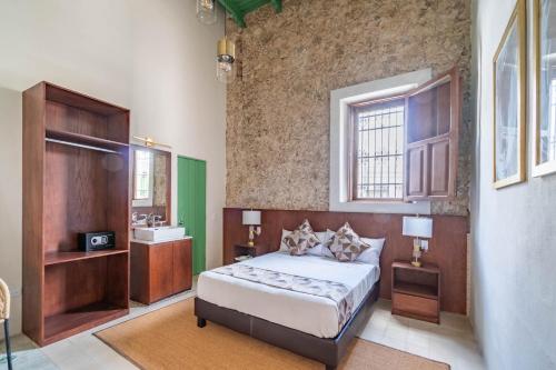 a bedroom with a bed and a sink in it at Hotel Boutique Santa Elena in Mérida