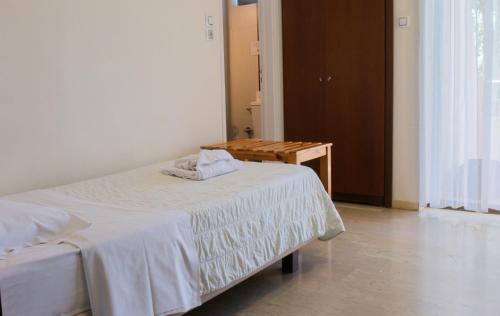 a bedroom with a bed and a wooden table at GOLDEN SUN Κokkoni Beach Hotel in Vrahati