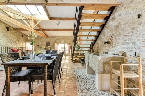 une salle à manger avec une table et des chaises et un mur en pierre dans l'établissement Loft centre-ville Parking, clim, wifi, à Carcassonne