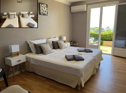 une chambre avec un grand lit et une grande fenêtre dans l'établissement Charming Villa-Appartement With A View On The Sea Of 95 M2, à Cannes
