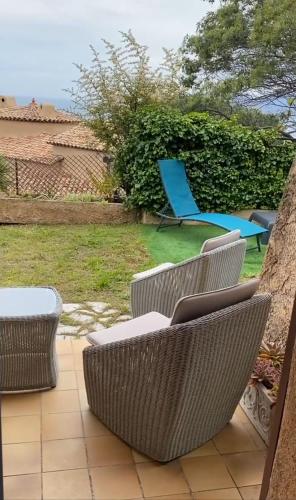 un groupe de chaises et une chaise bleue sur une terrasse dans l'établissement Charming Villa-Appartement With A View On The Sea Of 95 M2, à Cannes