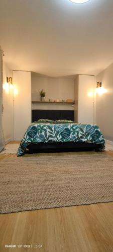 une chambre avec un lit avec une couverture dessus dans l'établissement Jolie studio, à Argenteuil