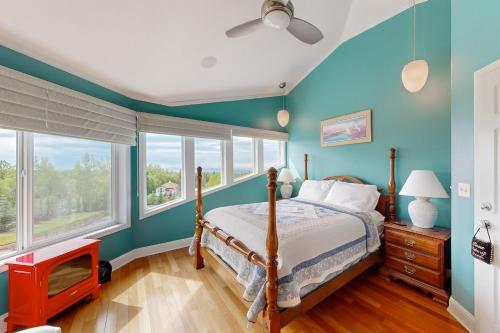 a bedroom with blue walls and a bed and a tv at Alaska Sundance Retreat in Anchorage