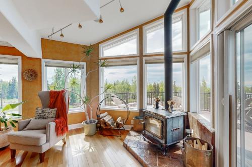 a living room with a fireplace and a chair and a stove at Alaska Sundance Retreat in Anchorage