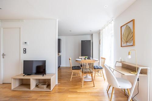 un salon avec une table à manger et une télévision dans l'établissement OIQIA • Téralis • Printanier, à Annonay