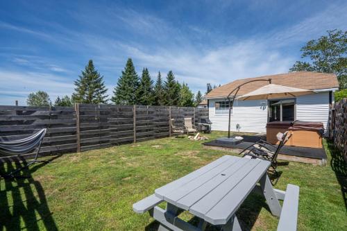 a backyard with a picnic table and an umbrella at Cheerful Cottage Close to Franconia Notch #4 in Carroll