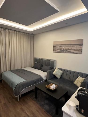 a living room with a bed and a couch at Studio with smart entry in Riyadh