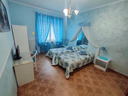 a bedroom with two beds and blue walls at Hotel Serenella in Turin