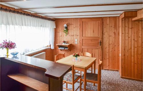 a kitchen with wooden paneling and a table and chairs at Lovely Home In Heideblick With Kitchen in Langengrassau