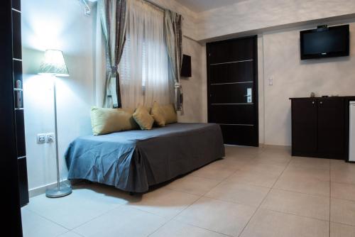 a bedroom with a bed with a window and a television at GOLDEN SUN Κokkoni Beach Hotel in Vrahati