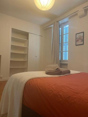 une chambre blanche avec un lit et une fenêtre dans l'établissement Appartement Centre Historique de Montluçon, à Montluçon