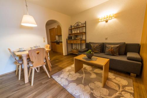a living room with a couch and a table at Pension Steinkogel in Sankt Leonhard im Pitztal