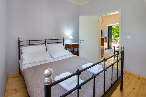 a bedroom with a large bed in a room at The Old One by All About Paxos in Kourtaíïka